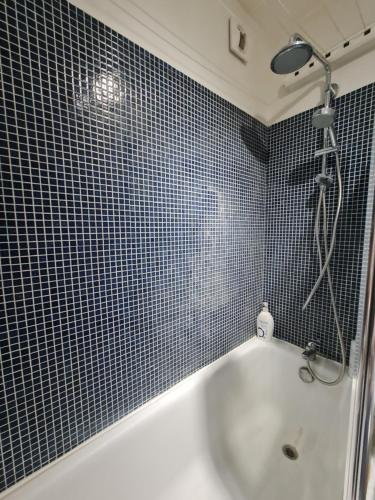 une salle de bain avec une baignoire blanche et une douche dans l'établissement Luminous Studio with Air conditioning, Eiffel Tower view, à Paris