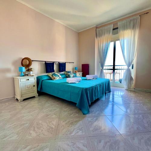 - une chambre avec un lit bleu et une fenêtre dans l'établissement Onda Blu Apartment, à Pizzo