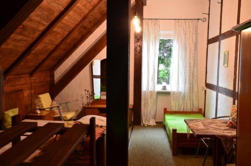 sypialnia z zielonym łóżkiem i oknem w obiekcie Stara Pastorówka w mieście Dąbki