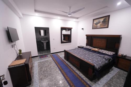 a bedroom with a bed and a mirror and a tv at Nights Inn Hotel in Islamabad
