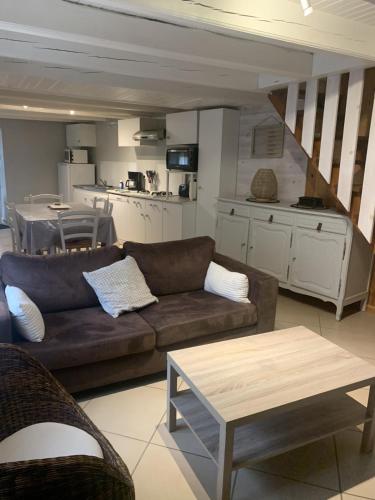 un salon avec un canapé et une cuisine dans l'établissement la clède aux lamas, à Vébron