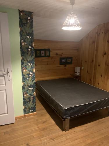 une chambre avec un lit dans une pièce aux murs en bois dans l'établissement la clède aux lamas, à Vébron
