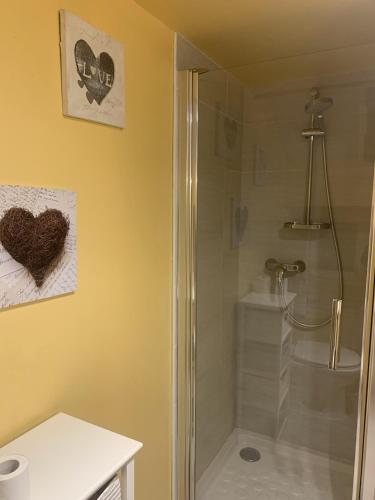 La salle de bains est pourvue d'une douche avec un cœur sur le mur. dans l'établissement la clède aux lamas, à Vébron