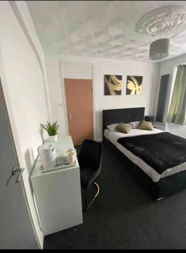1 dormitorio con 1 cama y 1 mesa con silla en Luxury king en-suite room en Peterborough