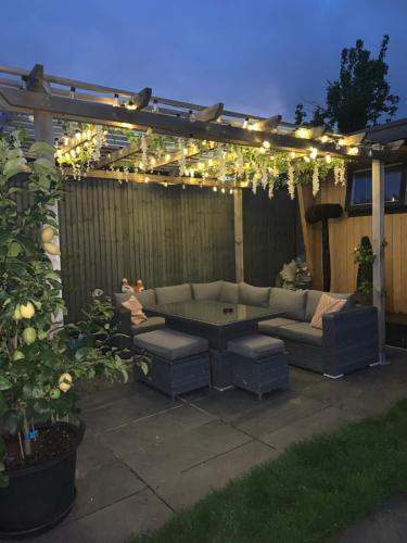 een patio met een bank, een tafel en verlichting bij Lindas LODGE Free PARKING air con plus provisions included in Hove
