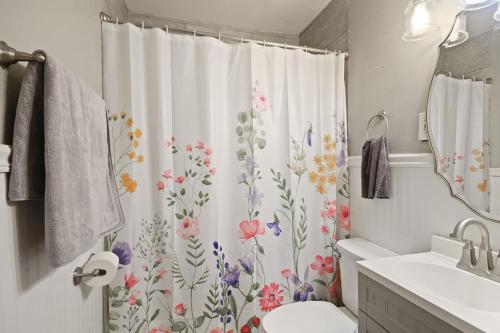 een badkamer met een douchegordijn met bloemen erop bij Down the Rabbit Hole walk to downtown in Columbia
