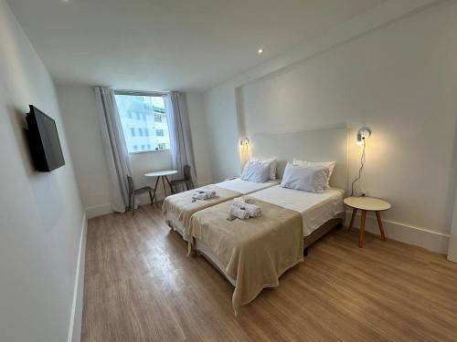 a bedroom with a large bed and a television at Maravilha in Rio de Janeiro