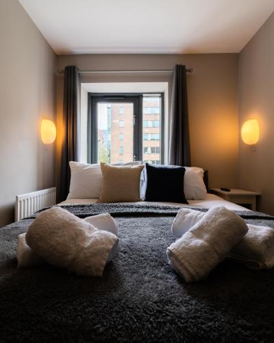 a bedroom with a large bed with two pillows on it at Belfast Quarters: Modern City Centre Hub 3 Bed in Belfast