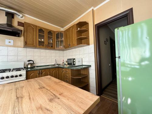 une cuisine avec des placards en bois et une table en bois dans l'établissement 2-х ком. квартира, р-н фонтан "ROSHEN", à Vinnytsia
