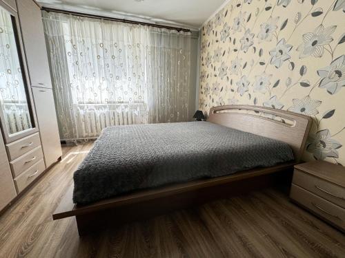 una camera con letto e parete con fiori di 2-х ком. квартира, р-н фонтан "ROSHEN" a Vinnycja