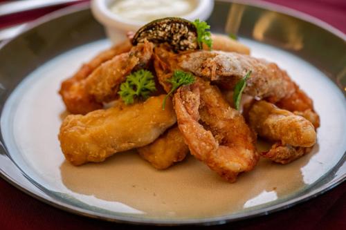 a plate of food with chicken wings and dipping sauce at Hacienda Samana Bay Hotel in Santa Bárbara de Samaná