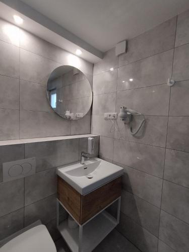 a bathroom with a sink and a mirror and a toilet at Pokoje u Krysi in Rzymkowice