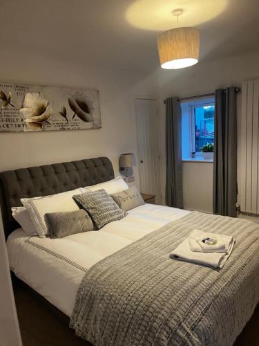 a bedroom with a large bed with a blanket at Lavender Cottage in Oundle