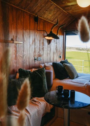 a living room with a couch and a table at ARA Cabin - Mêl in Pwllheli