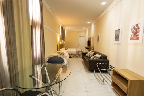 uma sala de estar com um sofá e uma cama em Wynn Batel em Curitiba