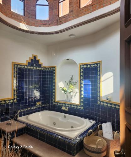 a bath tub in a bathroom with blue tiles at Tres Fuentes Dickinson Hotel Boutique in San Miguel de Allende
