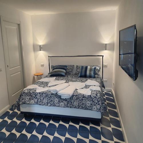 1 dormitorio con 1 cama y suelo azul y blanco en La casina del Conte en Nápoles