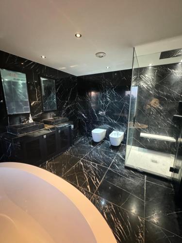 een badkamer met 2 wastafels en een glazen douche bij Chigwell Mansion in Theydon Bois