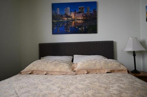 a bed in a bedroom with a painting on the wall at Oasis Suite in Niagara Falls