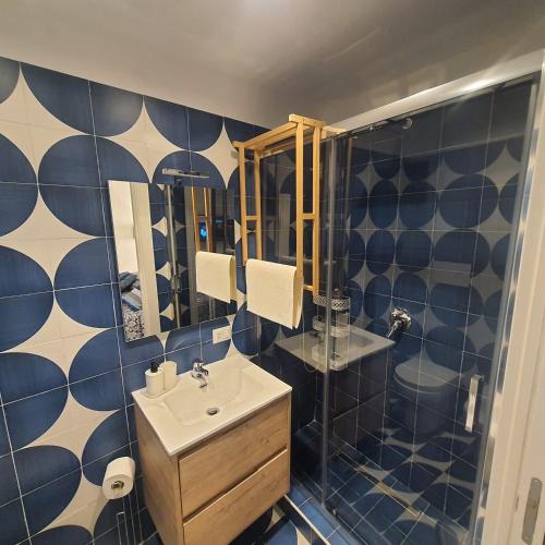 y baño azul y blanco con lavabo y ducha. en La casina del Conte en Nápoles