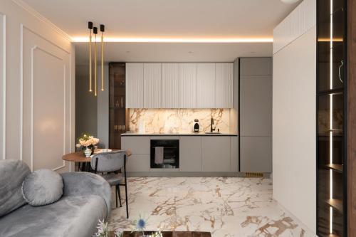 ein Wohnzimmer mit einem Sofa und einer Küche in der Unterkunft Beautiful Designer Apartment in Riga center in Riga