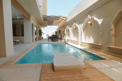 a swimming pool with a bench in a building at TK Royal & Spa in Hurghada