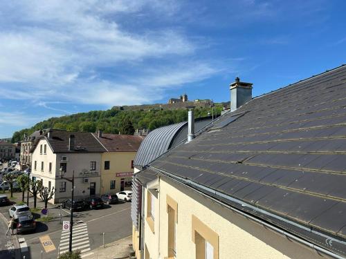 un techo de un edificio con un castillo en el fondo en Au coeur de Montmedy en Montmédy