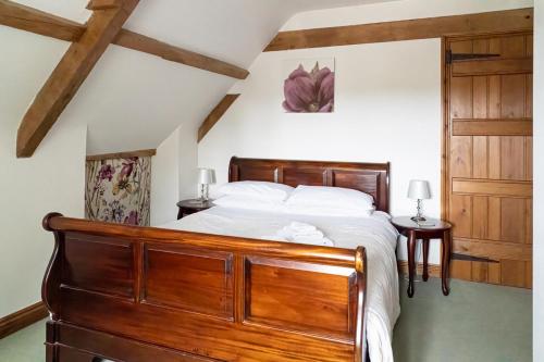 1 dormitorio con cama de madera con sábanas blancas en Coachmans Cottage in Loxton, en Loxton