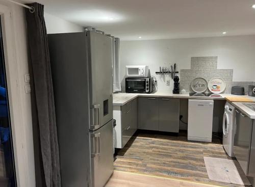 une cuisine avec un réfrigérateur et un micro-ondes dans l'établissement Un instant de bonheur, à Grasse