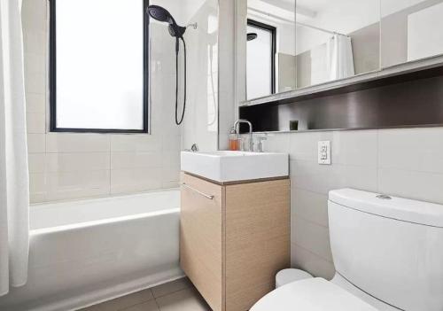 uma casa de banho com um lavatório, uma banheira e um WC. em Delancey Tower em Jersey City