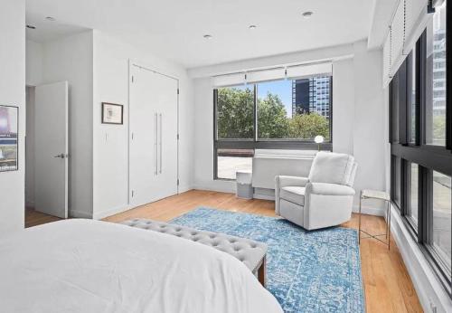 um quarto com uma cama, uma cadeira e uma janela em Delancey Tower em Jersey City
