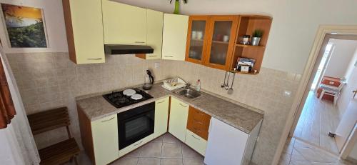 a small kitchen with a sink and a stove at Apartments Boćin Rosso in Hvar