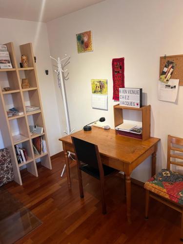 Habitación con escritorio de madera y mesa con silla. en Happy, en Givisiez