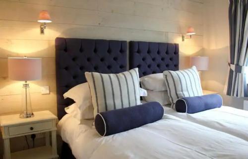 a bedroom with a large white bed with a blue headboard at MacKenzie Lodge in Lahinch