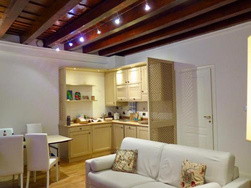 een woonkamer met een witte bank en een keuken bij Residenza Cappello18 in Verona