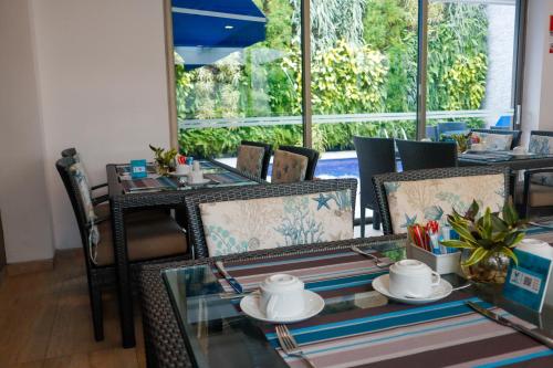 a dining room with tables and chairs and a window at Varanasi Hotel Boutique Aeropuerto in Cartagena de Indias