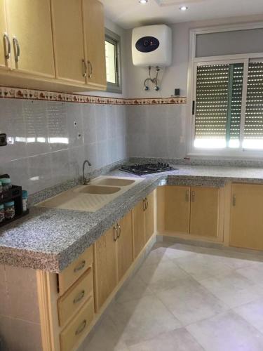uma cozinha com um lavatório e uma bancada em Appartement Plage & Famille em Ras El Ma