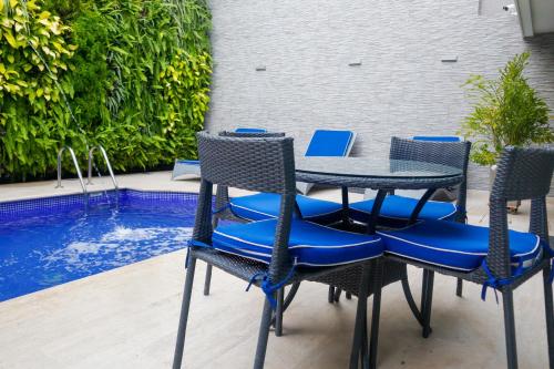 a table and chairs next to a swimming pool at Varanasi Hotel Boutique Aeropuerto in Cartagena de Indias