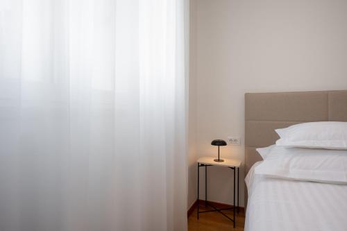 a bedroom with a bed and a table with a lamp at Adriatic Queen Residence in Split