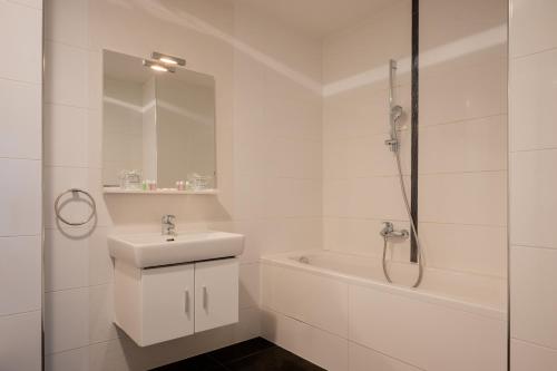 a white bathroom with a sink and a bath tub at Adriatic Queen Residence in Split