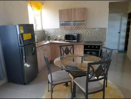uma cozinha com uma mesa e cadeiras e um frigorífico em Fabulous Apartments Barbados em Christ Church