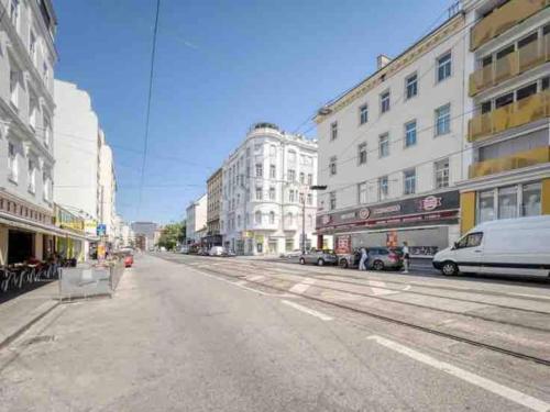 una calle urbana vacía con coches y edificios aparcados en Central apartment with balcony next Augarten Park, en Viena