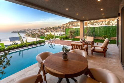 a patio with a table and chairs and a swimming pool at Marje Villas Bodrum in Bodrum City