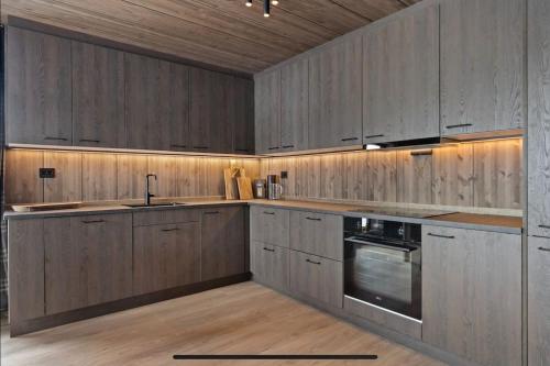 een keuken met houten kasten en een wastafel bij Stryn Wiew Logde Tverrfjellet in Stryn