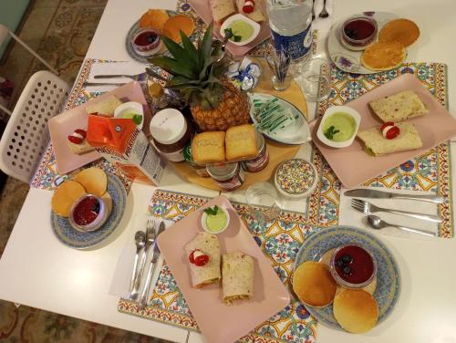einen Tisch mit Teller mit Lebensmitteln auf einem Tisch in der Unterkunft Corto Maltese Guest House in Cospicua