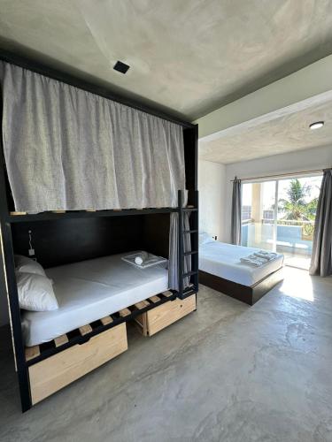 two bunk beds in a room with a window at Straw Hat Surf Hostel & Bar in Brisas de Zicatela
