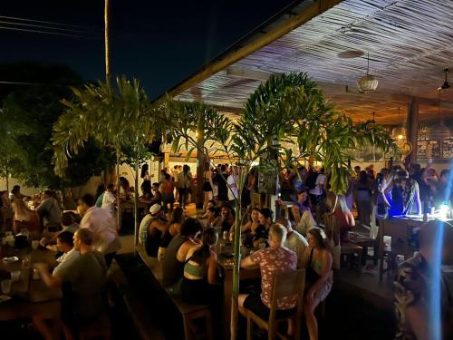 a group of people sitting at tables in a restaurant at Straw Hat Surf Hostel & Bar in Brisas de Zicatela