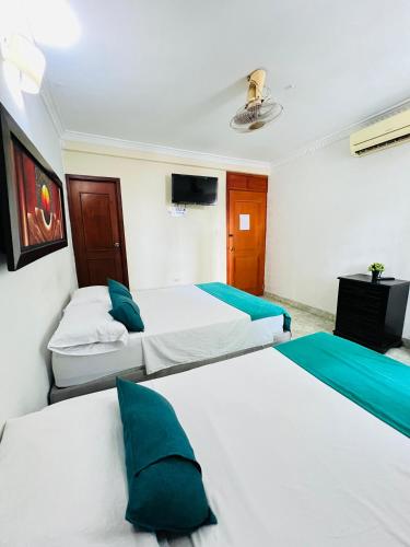 a bedroom with two beds and a tv in it at Hotel Coco Beach Santa Marta in Santa Marta