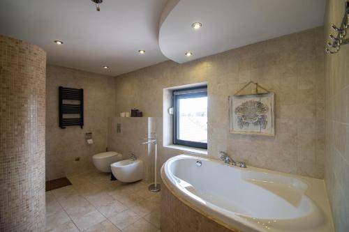 uma grande casa de banho com banheira e WC em Na Dubie em Zalewo