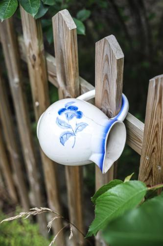 a blue and white bird feeder on a wooden fence at Na Dubie in Zalewo